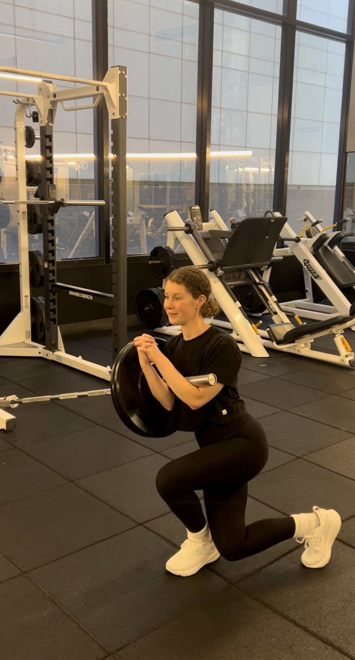 Female client squatting with barbell